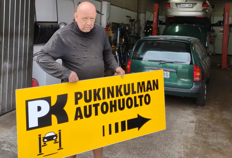 Mika Rintamäki ja autohuollon mainoskilpi